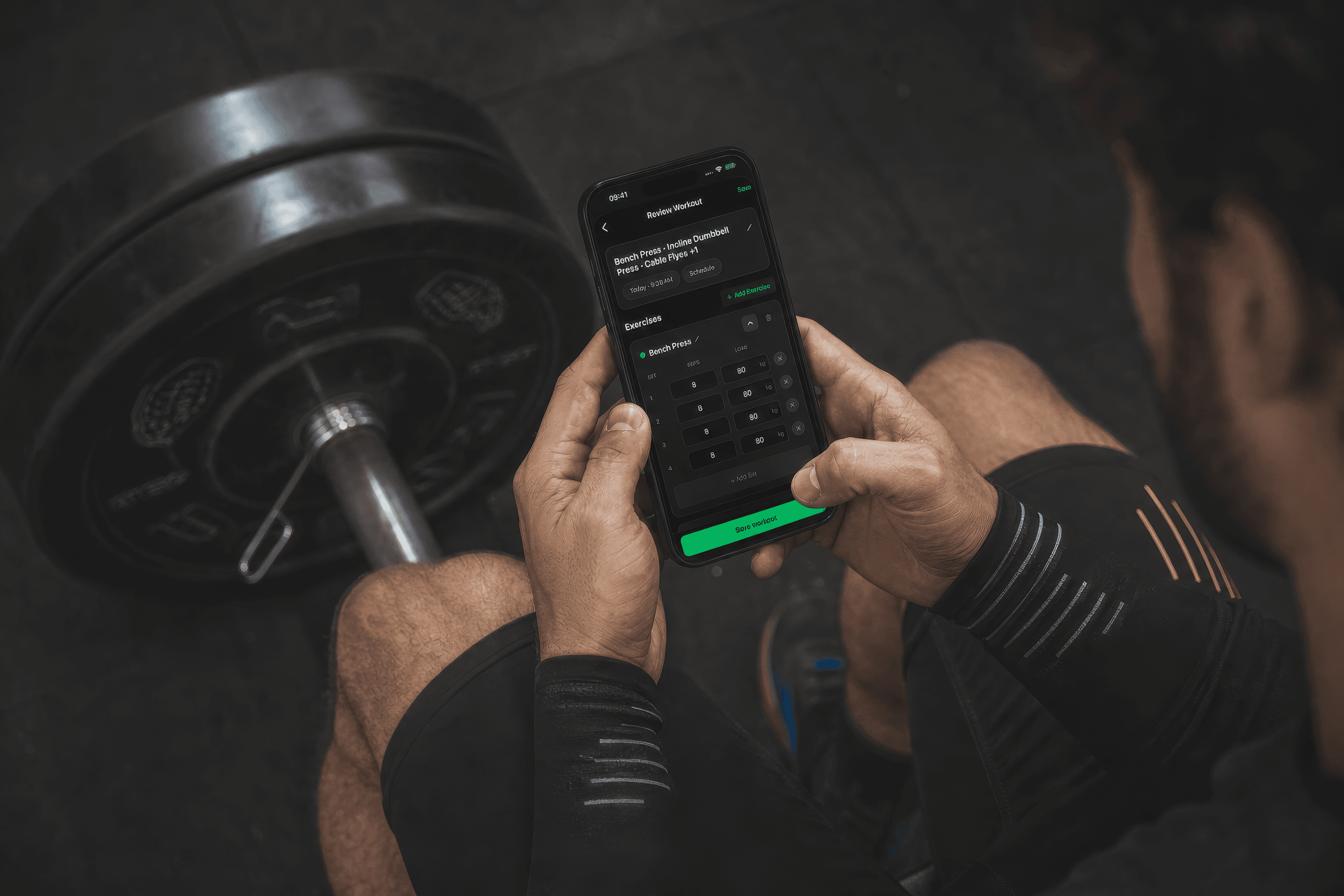 Ćwiczący przy sztandze sprawdza w GymNote serie wyciskania